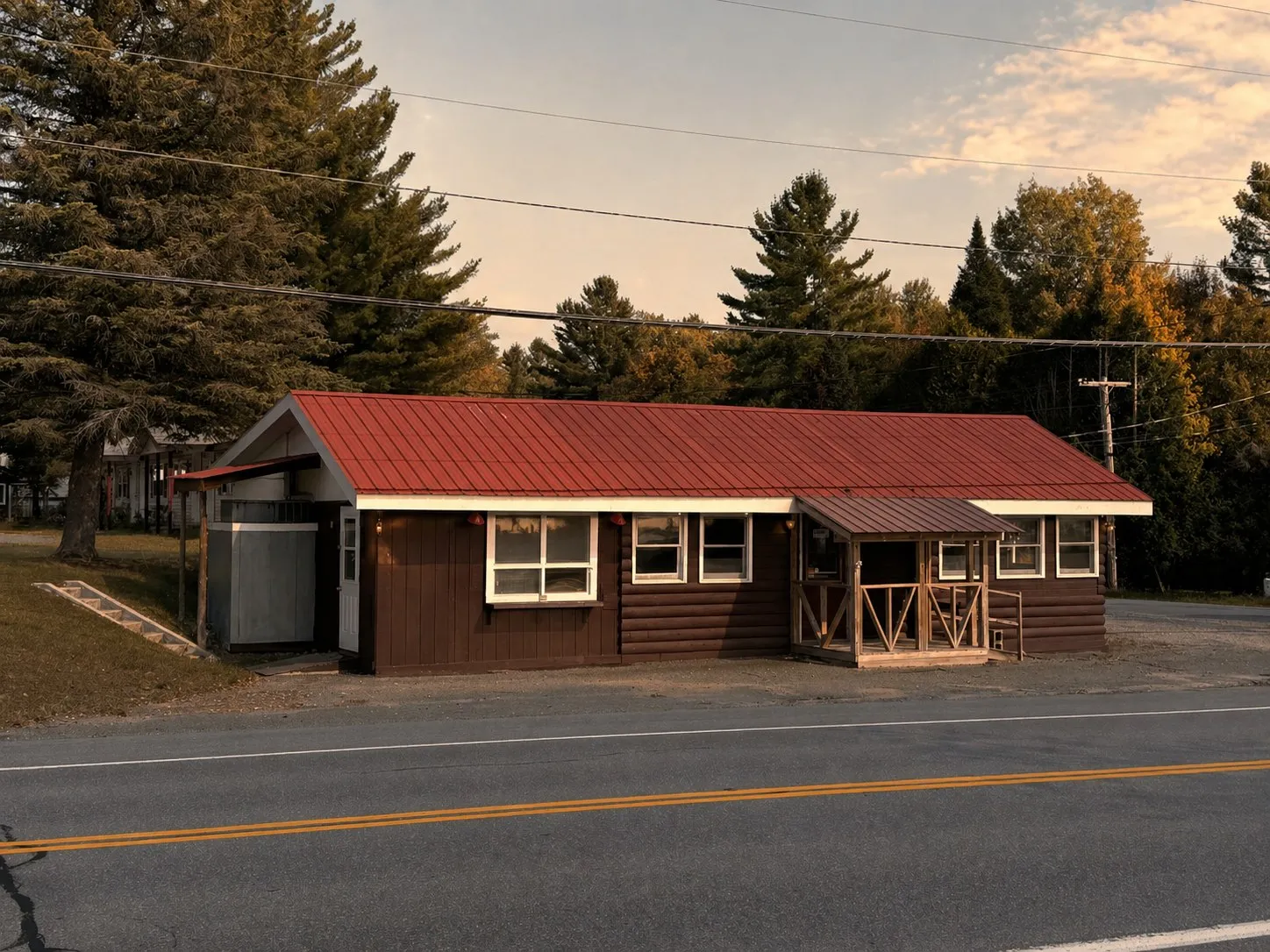 The front of Tilly's At Stone Manor at golden hour — the diner building with bright red metal roof and brown wood siding, where the ice cream window is.