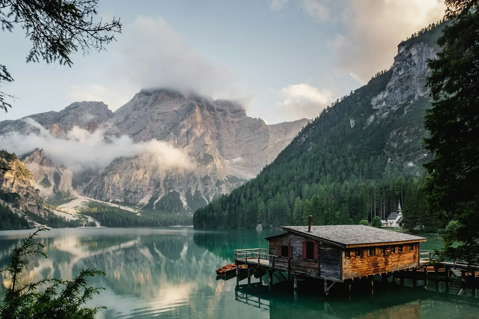 A small wooden dock reaching into a calm mountain lake.